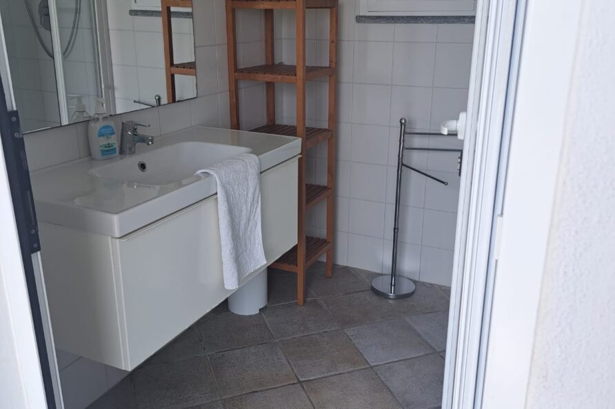 La Casetta della Baronessa — bagno con lavabo moderno e scaffale in legno