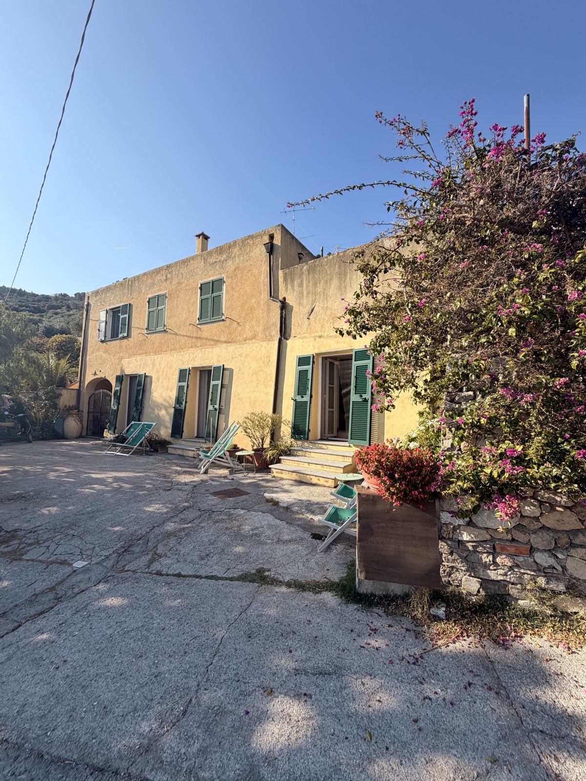 Camera Il Fico — facciata dell'agriturismo con bouganville e sdraio