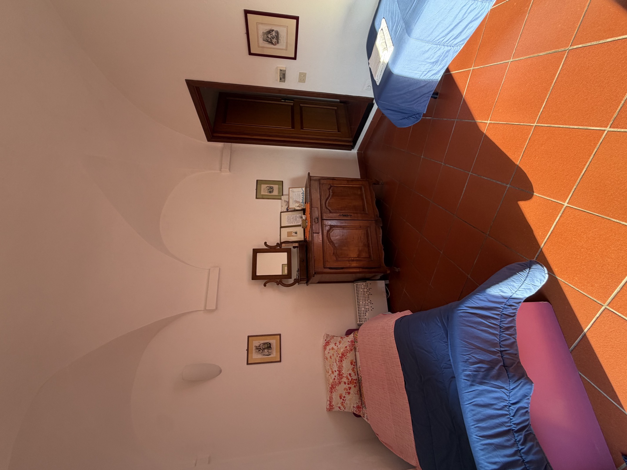 Camera Il Frantoio — angolo con armadio antico e finestra sul giardino