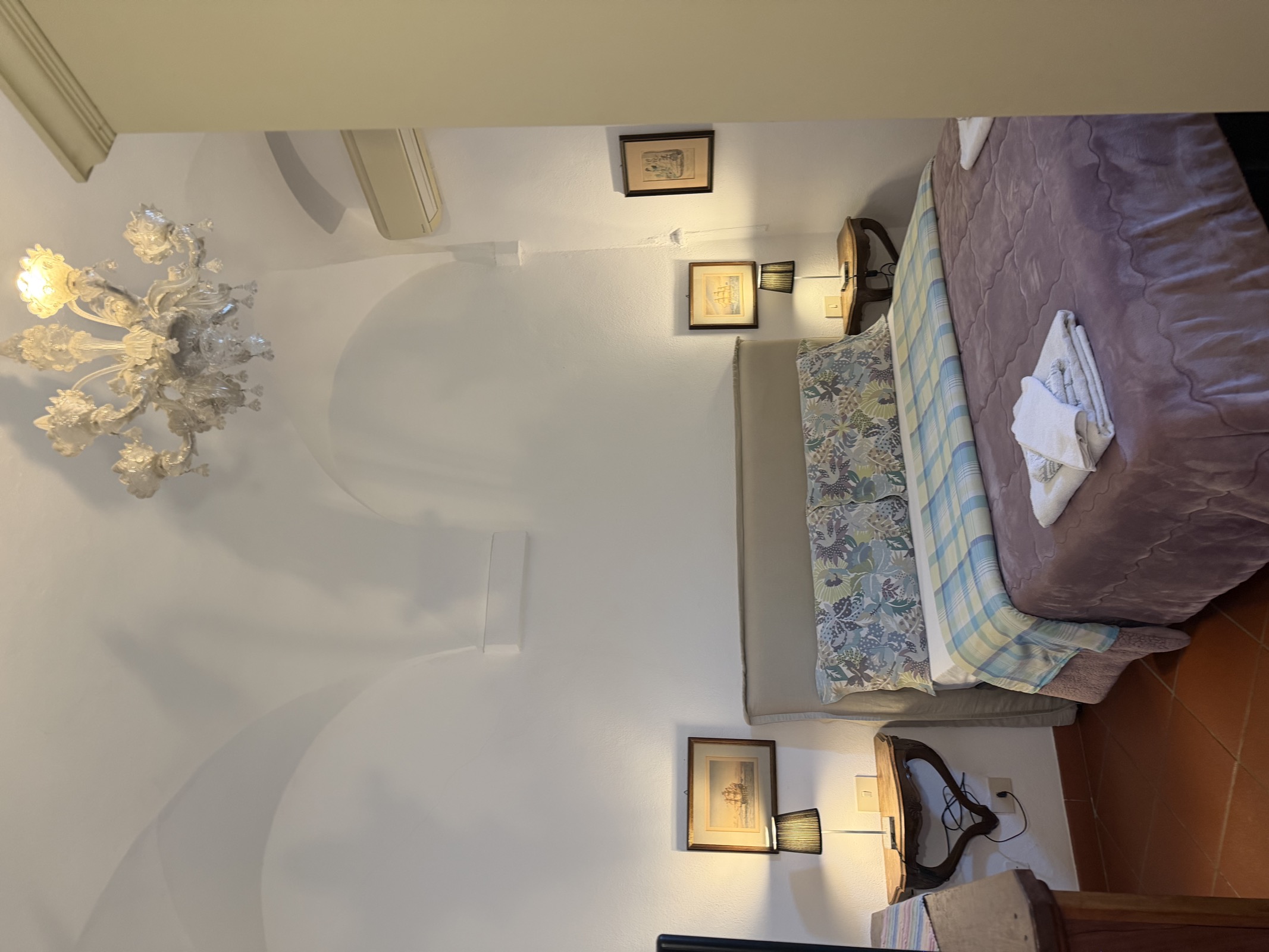 Camera Il Frantoio — letto con lampadario in vetro di Murano e volte bianche