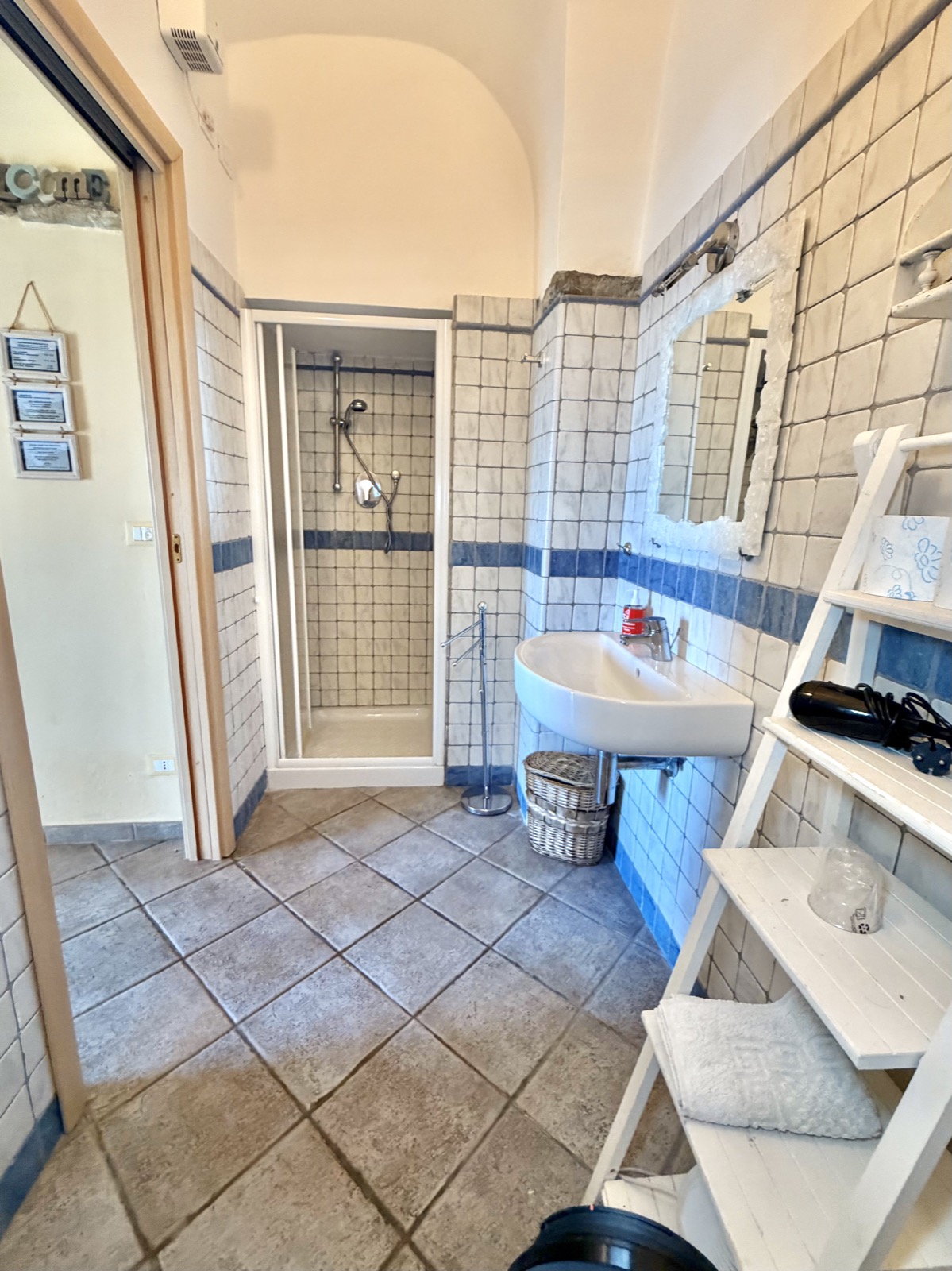 Camera Il Mare — bagno con piastrelle bianche e blu, doccia e lavabo