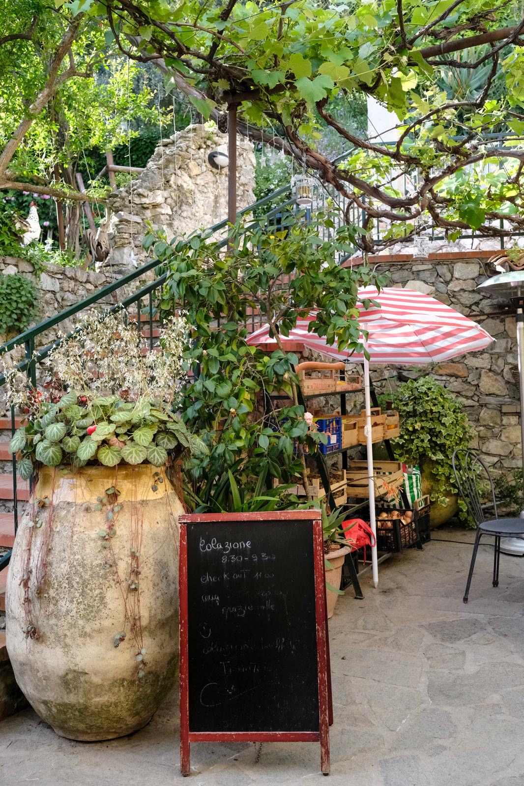 Grande giara in terracotta e lavagna del menu nel cortile del ristorante