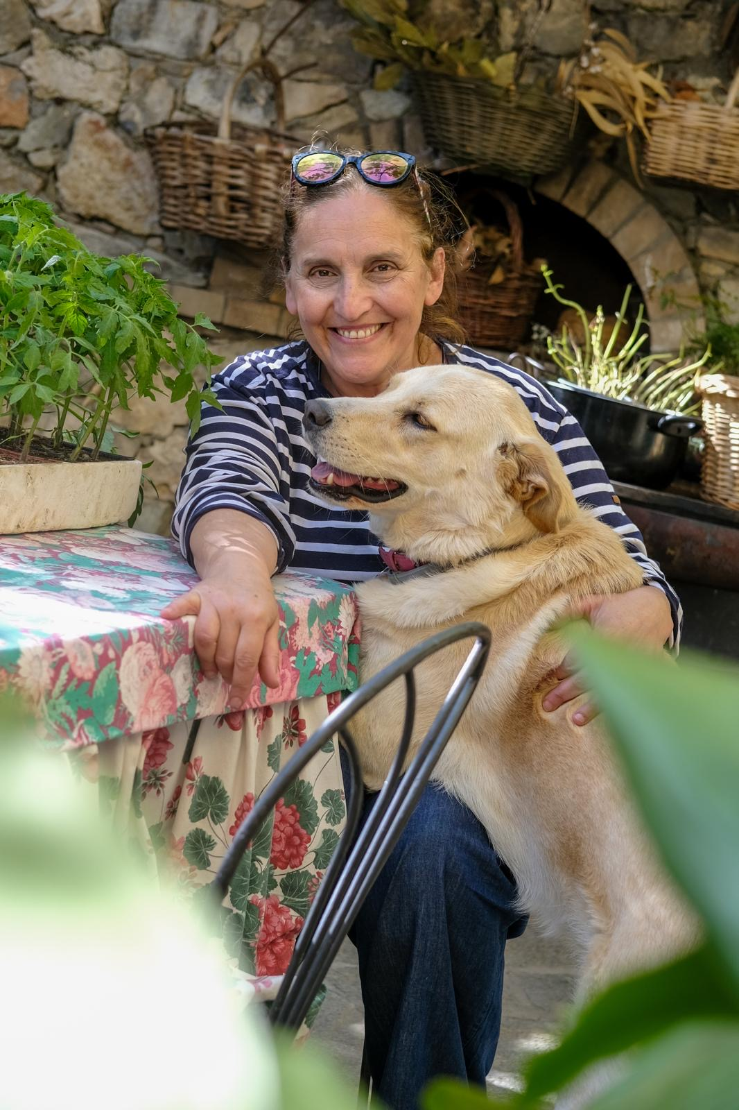 Giovanna, proprietaria dell'Agriturismo La Selva, sorridente nel giardino con il suo cane